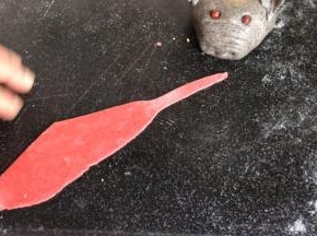 用红面擀成面皮，做一个头巾的样子