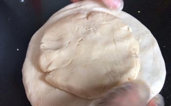 再把酥皮面团也压成饼，放在水油皮上