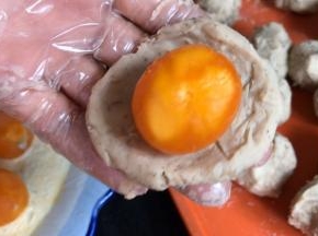 取一份捏成饼状，放入蛋黄包严实