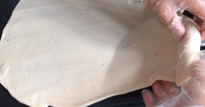 再从上往下，一边卷一边拉面皮，拉的越薄越好，卷成卷