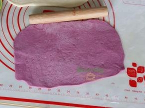 同理，去一个紫薯面团，用擀面杖把紫薯面团擀成大小和白面团一样。