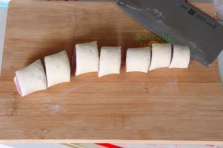 卷到接口处可以用擀面杖再次擀薄，让接口完美结合，没有缝隙。用刀切成3-4厘米，紫薯馒头胚就做好了。