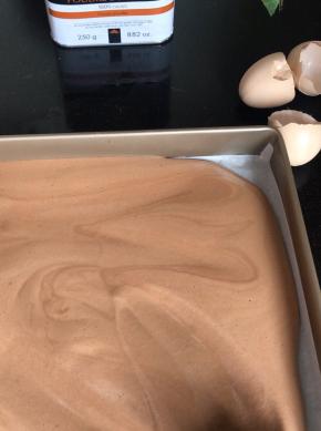 倒入铺好油纸的烤盘上，抹平好轻轻震动几下排气