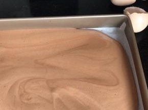 倒入铺好油纸的烤盘上，抹平好轻轻震动几下排气