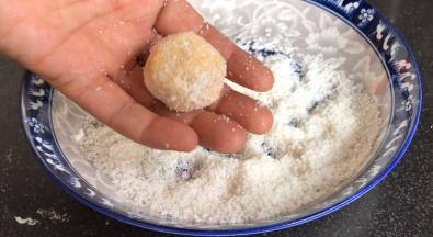 用手把土豆团裹满椰蓉，再搓成圆球