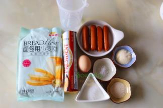 以下配料是4个面包食材：金龙鱼面包用小麦粉（高筋小麦粉）140克、牛奶75克、白砂糖20克、黄油15克、蛋液10克、盐1克、干酵母1克、脆皮火腿肠4根
表面装饰：全蛋液适量、白芝麻适量