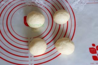 把发酵好的面团，挤出面团内的空气，分成4个小面团，滚圆，进行20分钟的中间发酵；