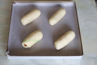 把做好的火腿面包胚均匀放入烤盘，烤箱内放一盘温水，把烤盘放入烤箱上层，时间45分钟，功能按发酵温度在38度左右