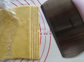 把黄色的面团擀成薄的长方形，切成细长条