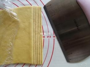 把黄色的面团擀成薄的长方形，切成细长条