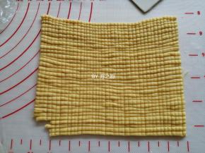 再把细条长每一根都搓一下，再把它们并排在一起。用刮板竖切一刀，不要切断，形成一个个小小的正方形格“玉米粒”