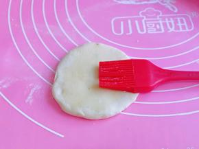 取一块面团，用擀面杖擀两下，再刷上食用油。
