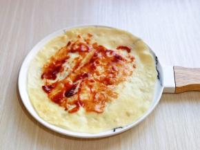 取一张饼从中间揭开，一张饼就变成两张啦！涂上甜面酱。