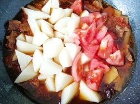 一个小时之后，下入土豆块和剩下的一半西红柿翻炒均匀，继续中小火炖10分钟左右(土豆熟了即可)。