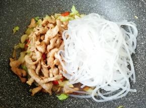 下入炒好的肉丝和泡好的粉条翻炒均匀。