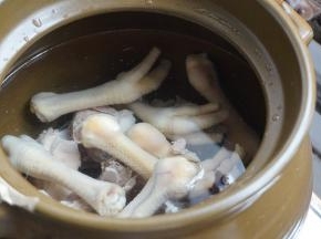 瓦锅里先放猪骨和鸡脚