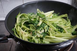 打开盖子，可以看到通心菜已经软软的了。翻炒片刻，使其受热均匀