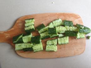 首先将黄瓜洗干净，因为是生吃的，可以用暖开水烫一下外皮，如果是自家种植的放心食品，当然就不需要啦。将黄瓜放在案板上，既然是拍黄瓜，当然要用刀将黄瓜来回拍两遍，拍到它裂开，更易入味，再切成小块，容易入口