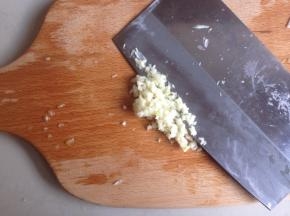 蒜去外衣，用刀将蒜拍扁，再剁成蒜蓉