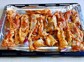 取出腌制好的羊排，烤盘铺上锡纸，把洋葱铺在下面，羊排摆放在洋葱上面。