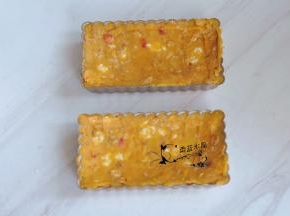 把混合物填入派盘中，刮平模具边缘，抹成中间低四周高的效果。