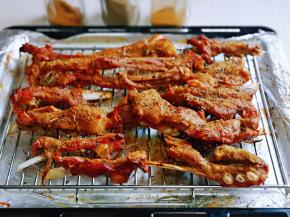 40分钟后取出烤盘，将汤汁倒掉，把羊排摆放在烤网上，烤网放在烤盘上面，撒上孜然粉。迷迭香。