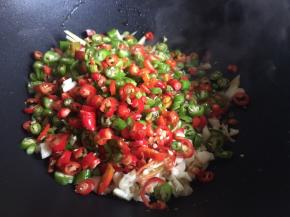 起锅热油了，倒入适量油，无需太多，油一定要烧热后倒入辣椒碎、蒜末、姜碎，不停翻炒；