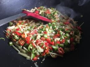 不停翻炒，变色后倒入半勺盐，继续不停翻炒至辣椒炒出辣味即可装盘备用，辣椒无需炒至7~8分熟即可；
