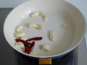 热锅凉油，爆香蒜头和干红辣椒。