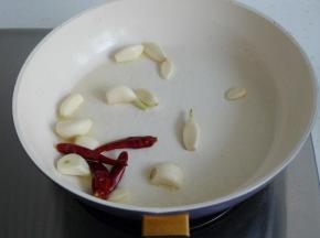 热锅凉油，爆香蒜头和干红辣椒。