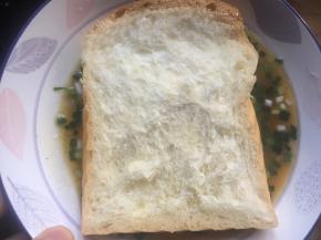 将吐司片放入碗中，停留几秒立马取出；（注意时间不要太长，吐司吸满鸡蛋液容易化）