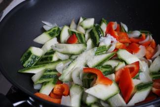 倒入红椒、丝瓜和百合，加入适量盐和糖，炒至入味