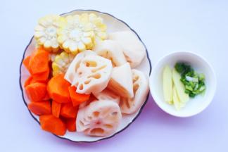 莲藕去皮洗净切厚片，胡萝卜去皮洗净切滚刀块，玉米切断，姜切片，葱切末。