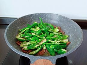 加入青辣椒翻炒。