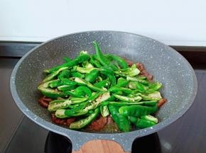 加入青辣椒翻炒。