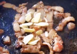 肉片炒变色，放入大蒜片翻炒