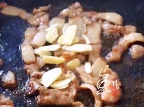 肉片炒变色，放入大蒜片翻炒