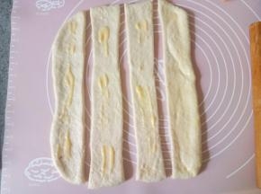 然后切成两指宽的长条4条，把刚才拌匀的黄油炼乳酱涂抹到面片上，抹均匀