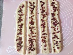 再撒上蔓越莓干，把蔓越莓干稍微按压一下，以防后面会掉落。（炼乳不要都用完，后面还要刷面用。）