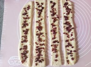 再撒上蔓越莓干，把蔓越莓干稍微按压一下，以防后面会掉落。（炼乳不要都用完，后面还要刷面用。）