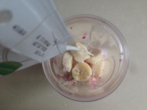 将火龙果肉和香蕉果肉切小块，分成两份，其中一份火龙果肉少一些，放进料理杯中，倒入一半的牛奶