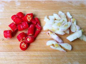 准备红椒圈，大蒜瓣用刀拍碎，再切几刀。