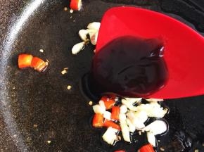 油热后先放红椒圈、蒜碎炒出香味，放入蚝油，煸炒十下。