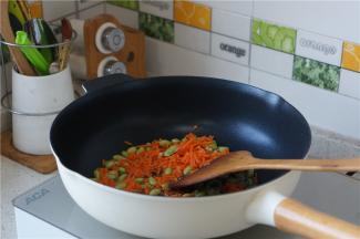 热锅加油，将青豆及胡萝卜先下锅炒香炒出味，青豆不易熟，这样子煸煎一下，就熟的很快。