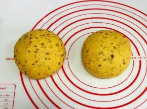 发酵好的面团取出排气，均分成两份，接着滚圆，盖好保鲜膜松弛10分钟。