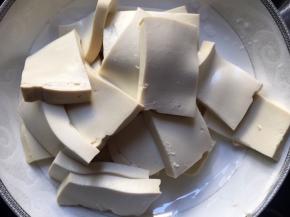 将豆腐切成均匀大小的薄方片；