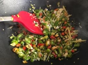 起锅热油了，倒入适量油，无需太多，油一定要烧热后倒入辣椒碎、蒜末、姜碎，不停翻炒；