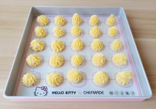 将曲奇挤到学厨的饼干垫子上。