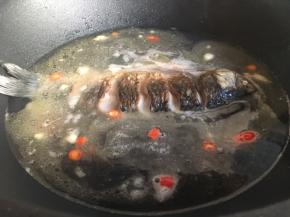 倒入一大碗的热水或开水，水量则根据鱼的大小来定，没过鱼身最佳。大火煮至沸腾后转成中火，盖上锅盖焖煮。