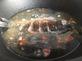 倒入一大碗的热水或开水，水量则根据鱼的大小来定，没过鱼身最佳。大火煮至沸腾后转成中火，盖上锅盖焖煮。